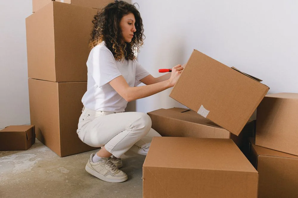 A woman writing on a moving box